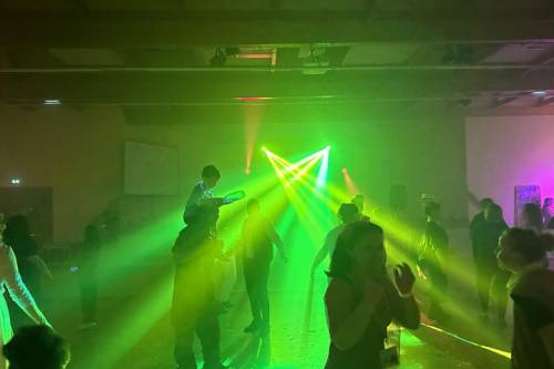 Ambiance de soirée avec faisceaux laser verts au-dessus du public