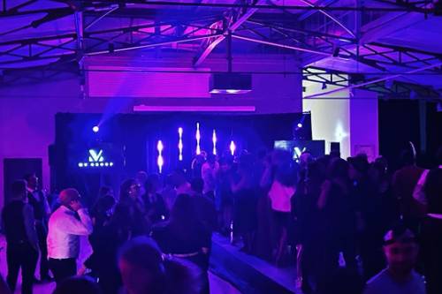 Piste de danse avec public sous un éclairage violet lors d’une soirée