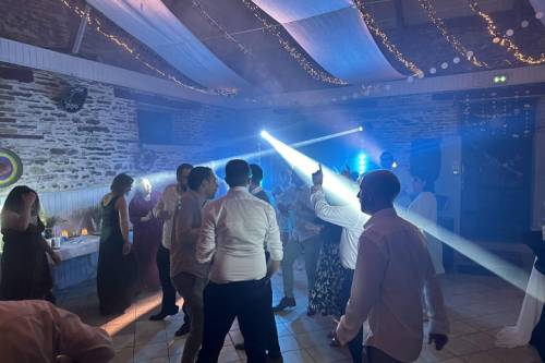 Invités sur la piste de danse avec faisceaux lumineux dans une salle en pierre
