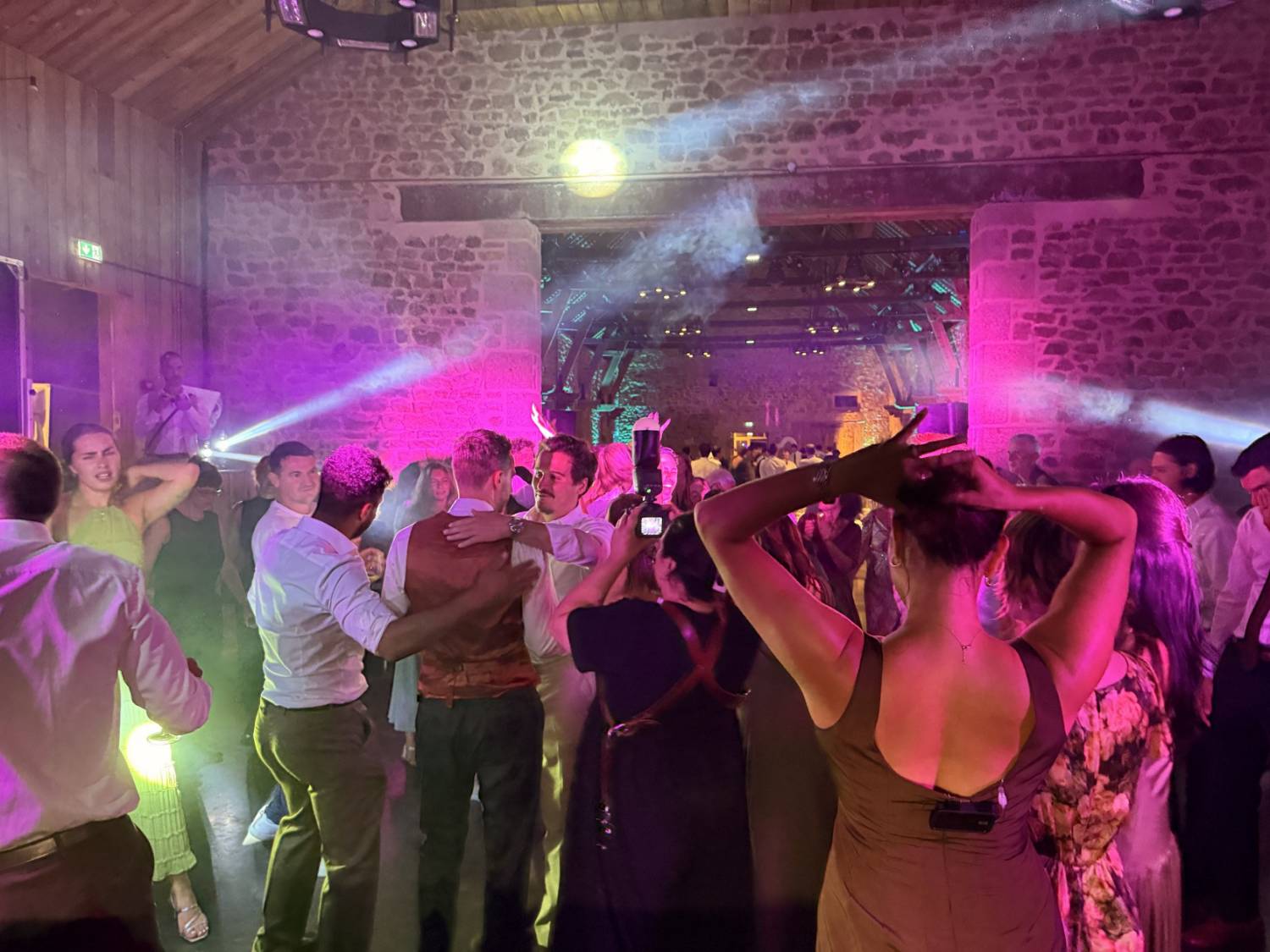 Invités dansant lors d’un mariage au Château du Rocher Portail avec éclairage rose