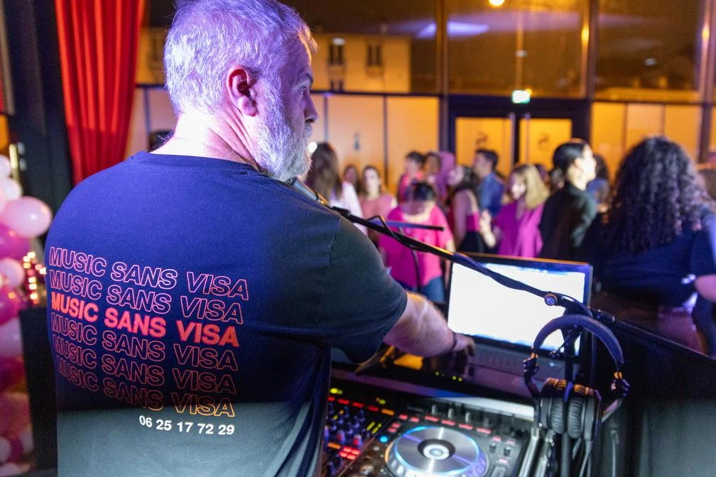 DJ Music Sans Visa, en prestation lors d’une soirée dansante à Rennes, aux platines devant un public sur la piste de danse